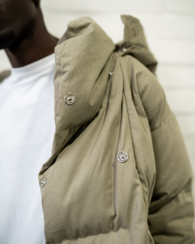 Close up of khaki puffer jacket snap button details