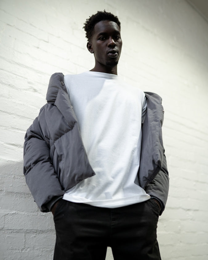 Australian Charcoal puffer jacket worn off-shoulder by male model