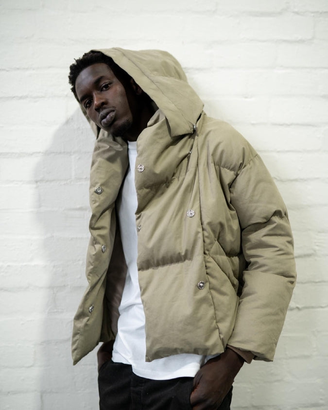 Hooded khaki puffer jacket worn by male model