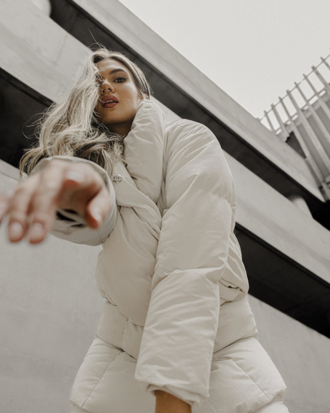 Stone long puffer jacket worn by female model up close