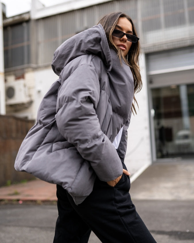 Charcoal puffer jacket worn by female model outdoors