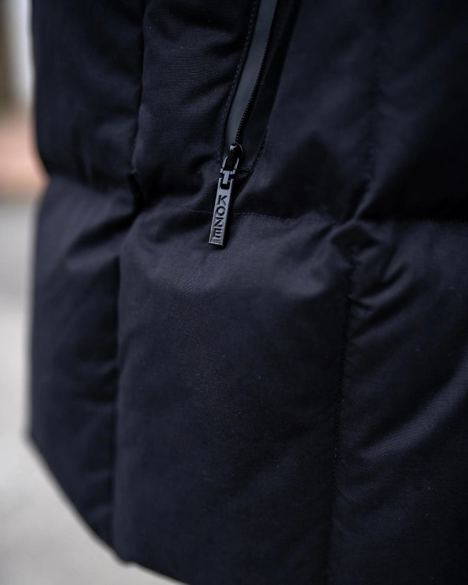 Close up of black puffer vest external zipper