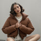 Cropped chocolate brown puffer jacket worn my female model sitting down