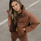 Chocolate cropped puffer jacket worn by female model