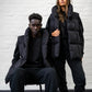 Black Longline Puffer Vest worn by male and female model