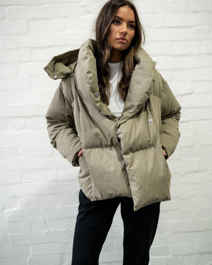Khaki puffer jacket worn by female model front view
